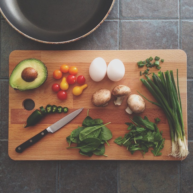 A lunch cooler bag with vegetables and eggs on a cutting board.