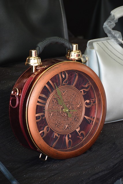 A purse alongside a clock on a table.