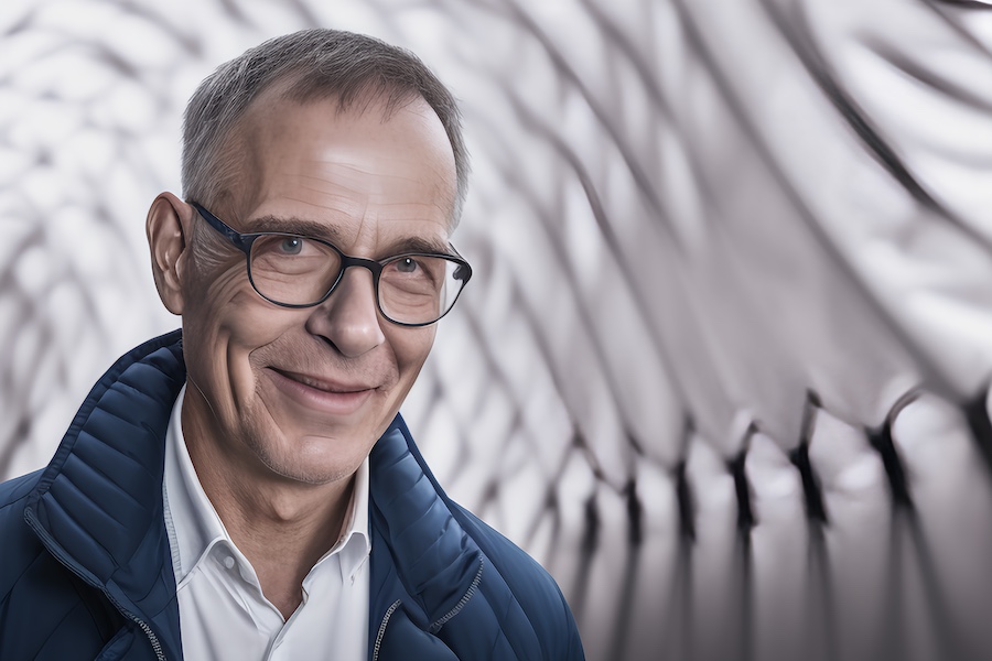 A man in glasses is smiling.
