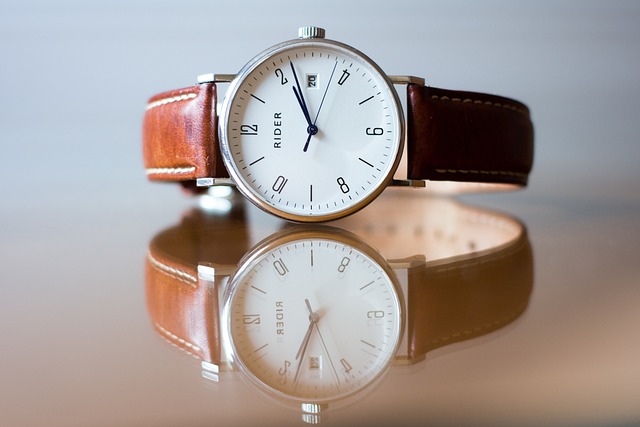 A leather wrist watch with a brown strap sitting on a table.