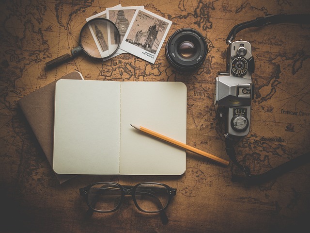 A smart wallet for men with notebook and glasses on a wooden table.