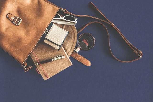 A brown leather bag with a pair of sunglasses and a notebook, perfect as a smart wallet for men.