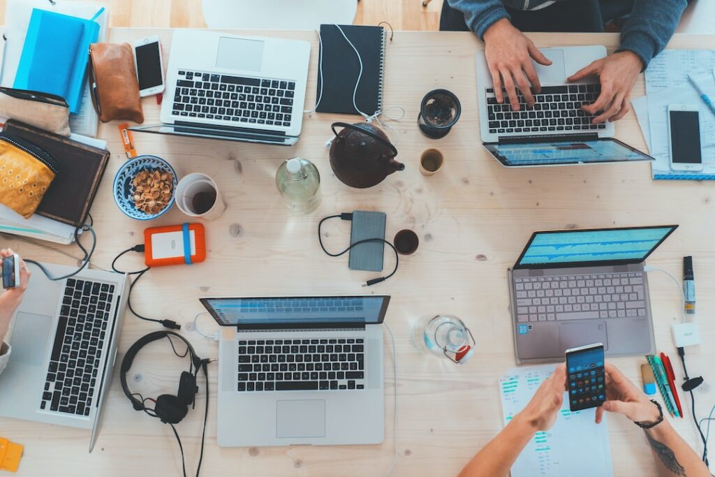 A group of people working on laptops at a table, giving their best effort.