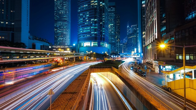 Hong Kong city at night, with locals and tourists carrying small crossbody bags.