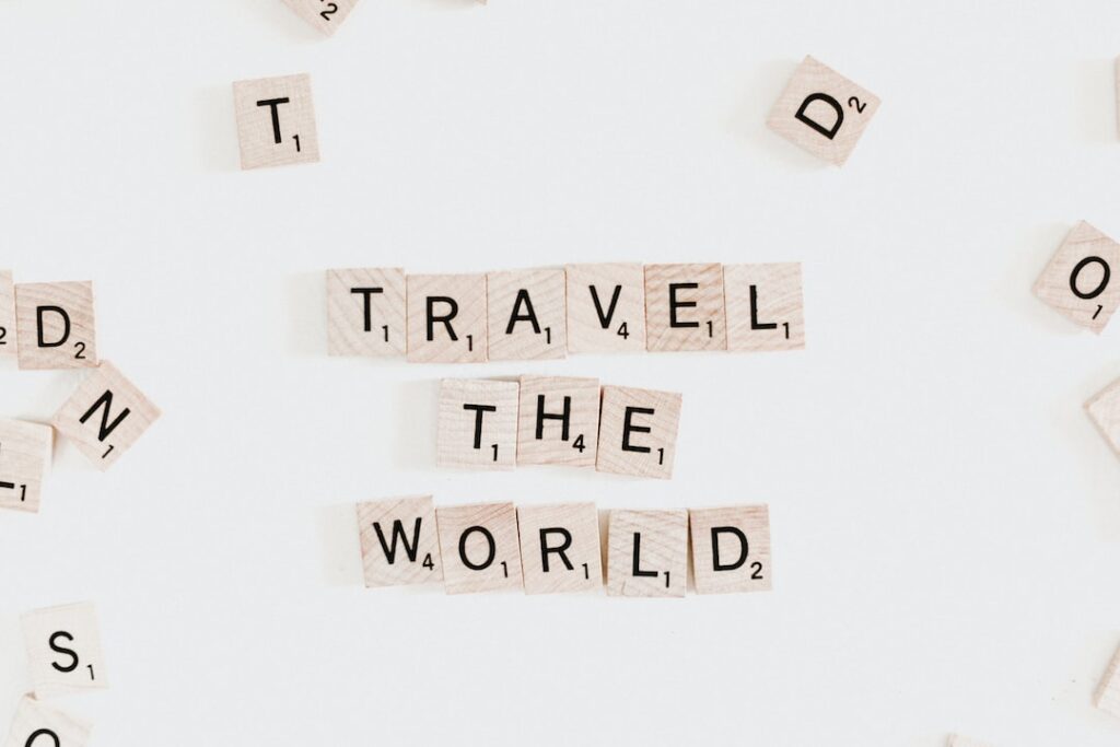 Small crossbody bag with scrabble letters spelling out destinations around the world.