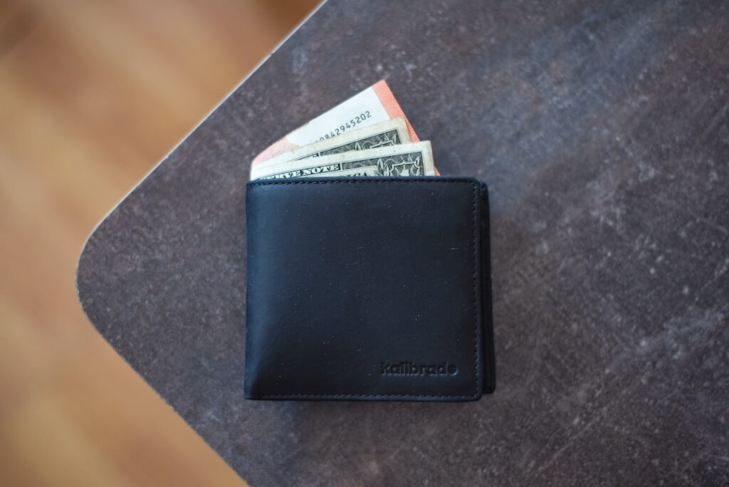 An outstanding black leather wallet sitting on top of a table.