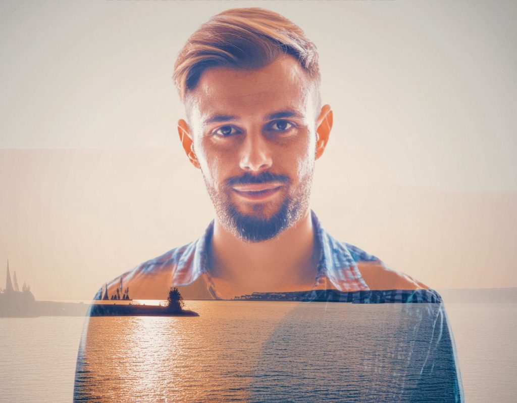 Double exposure of a bearded man in a plaid shirt, his profile blending with a serene sunset lake. Reflects rugged outdoor fashion and timeless style.
