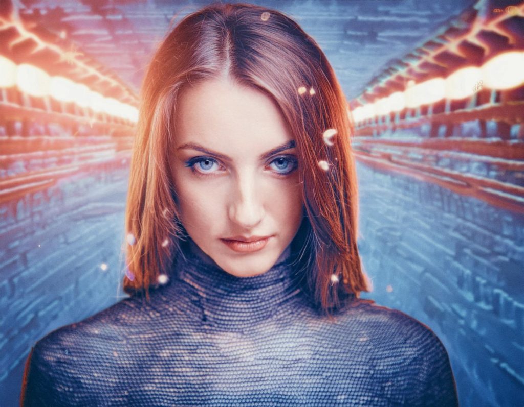 A woman with shoulder-length hair and piercing blue eyes in a high-neck, textured top stands against a futuristic tunnel, reflecting Samsonite x Google Jacquard's elegance.