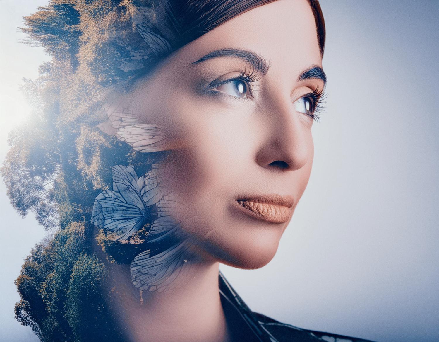 A woman's serene face merges with an artistic overlay of trees and leaves, sunlight dancing through foliage. Perfect vision enhanced by her chic Osprey Pack.