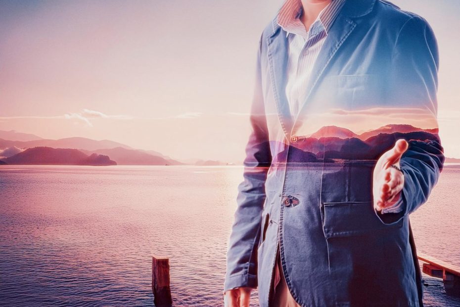 A person in a blue blazer and striped shirt extends their hand for a handshake. A serene lakeside sunset overlays, blending fashion with tranquility.