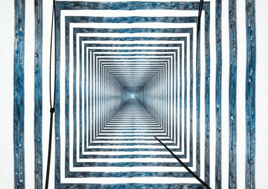 Bold blue and black squares form a chic, tunnel-like pattern—an avant-garde backdrop for strikingly asymmetrical fashion statements.