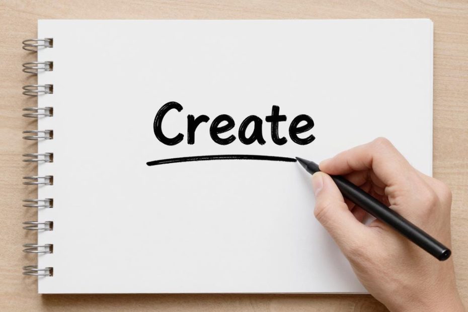 A hand writes 'Create' in bold black letters on a white spiral notebook—an inspiring start for designing trendy DIY bag charms.